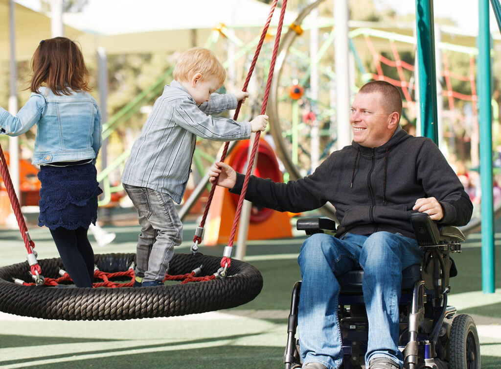 paraplegic father swinging his children at the park springfield illinois