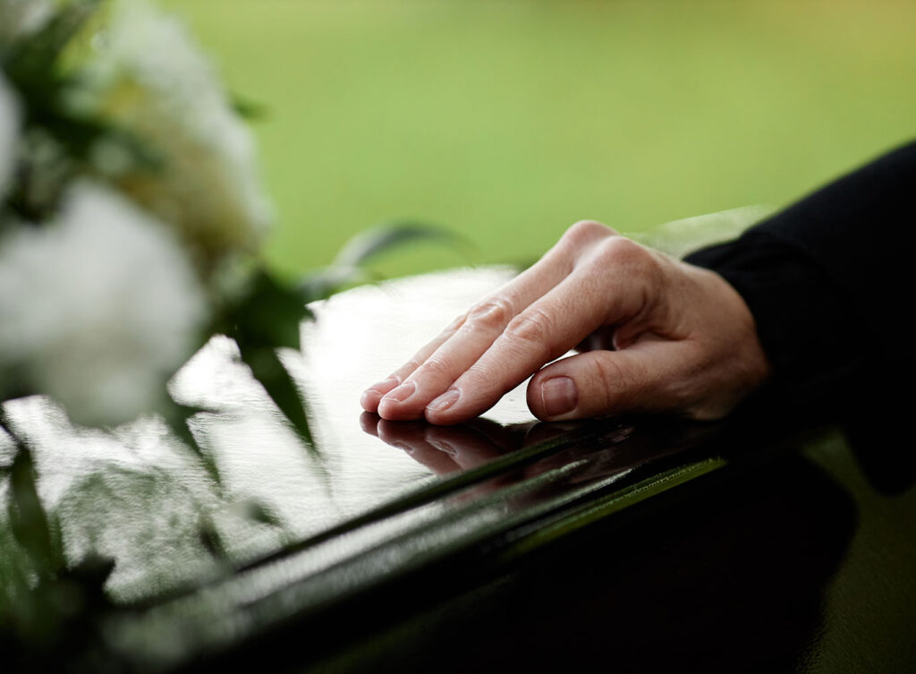 woman placing her hand on a casket at a wrongful death funeral springfield illinois